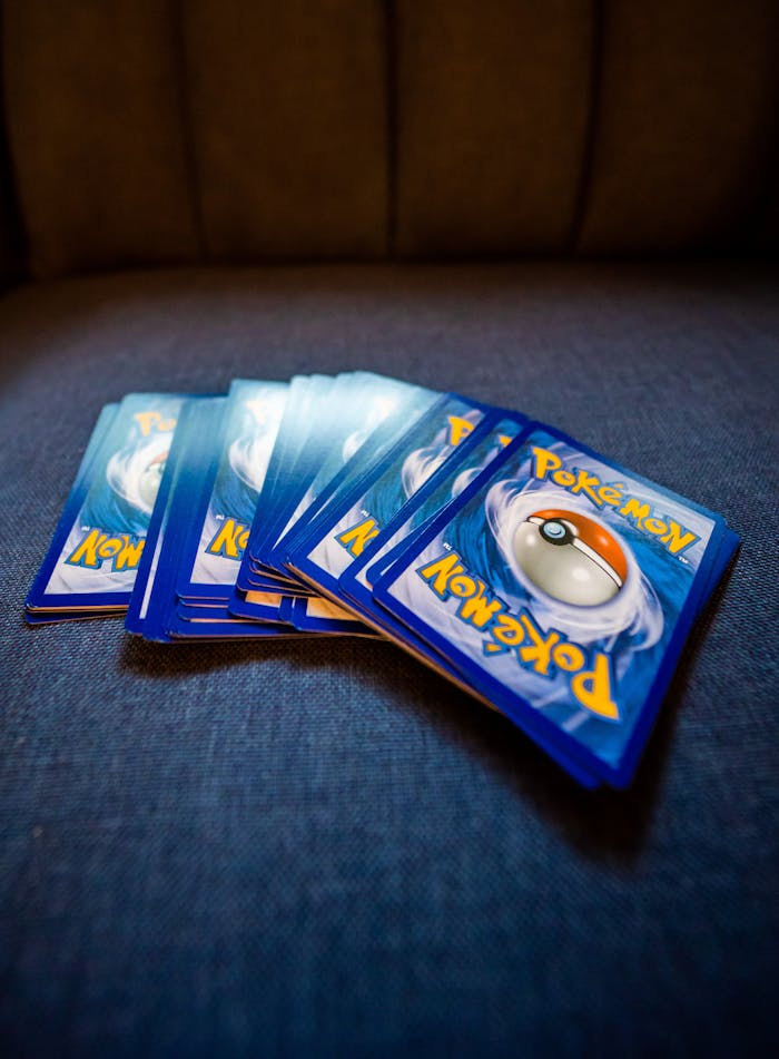 Services-03 A collection of Pokemon trading cards arranged on a blue couch, ideal for collectors and fans.