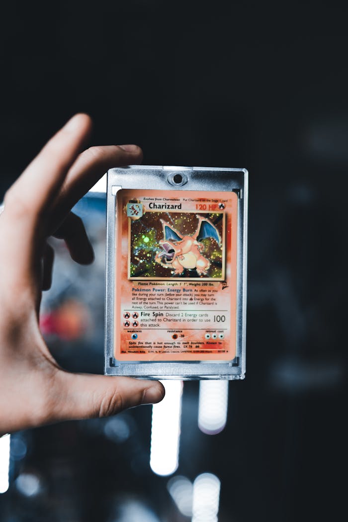 creative A detailed view of a Charizard Pokémon card held by a hand, iconic and collectible.